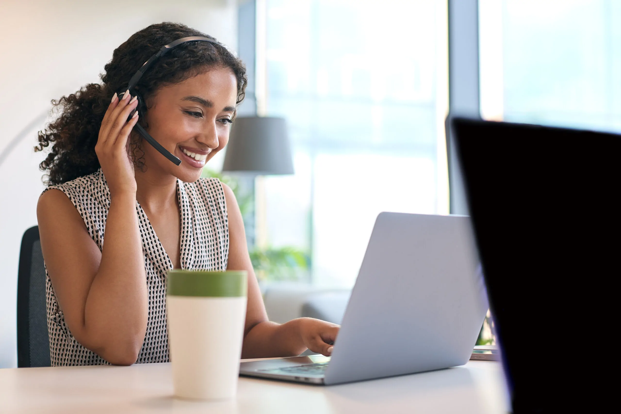 woman wearing headset sitting at desk with laptop 2026 01 05 06 29 22 utc scaled